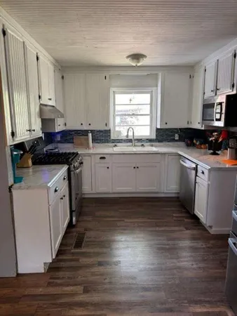 a kitchen with a sink stove top oven and cabinets