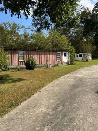 a front view of a house with a yard and trees