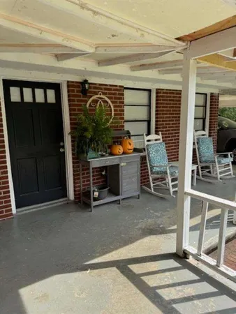 a view of a porch with furniture and floor to ceiling window