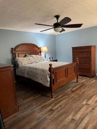 a bedroom with a bed and a ceiling fan