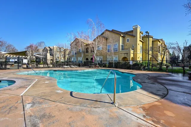 a view of a white house with a big yard and large trees
