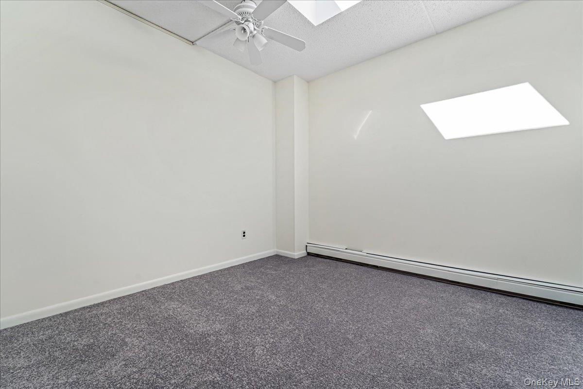 71-29 Sutton Place, Unit 3 Queens, NY 11365 - Photo 13 of 24 an empty room with a window and a fan