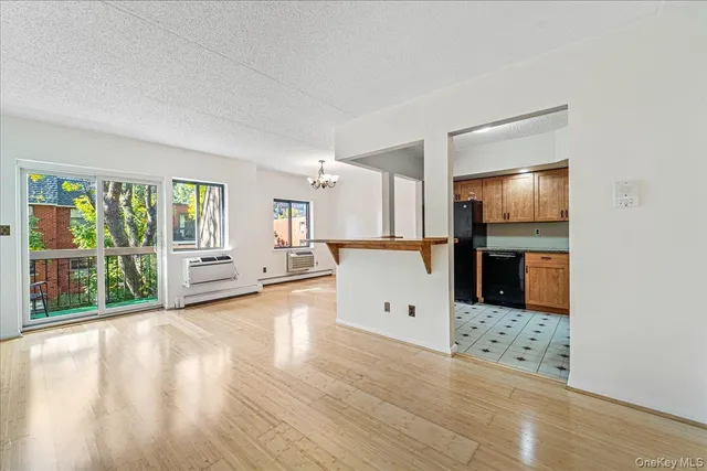 a view of a living room hardwood floor and a kitchen
