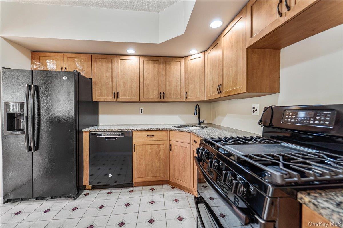 71-29 Sutton Place, Unit 3 Queens, NY 11365 - Photo 8 of 24 a kitchen with stainless steel appliances granite countertop a stove a refrigerator and a sink
