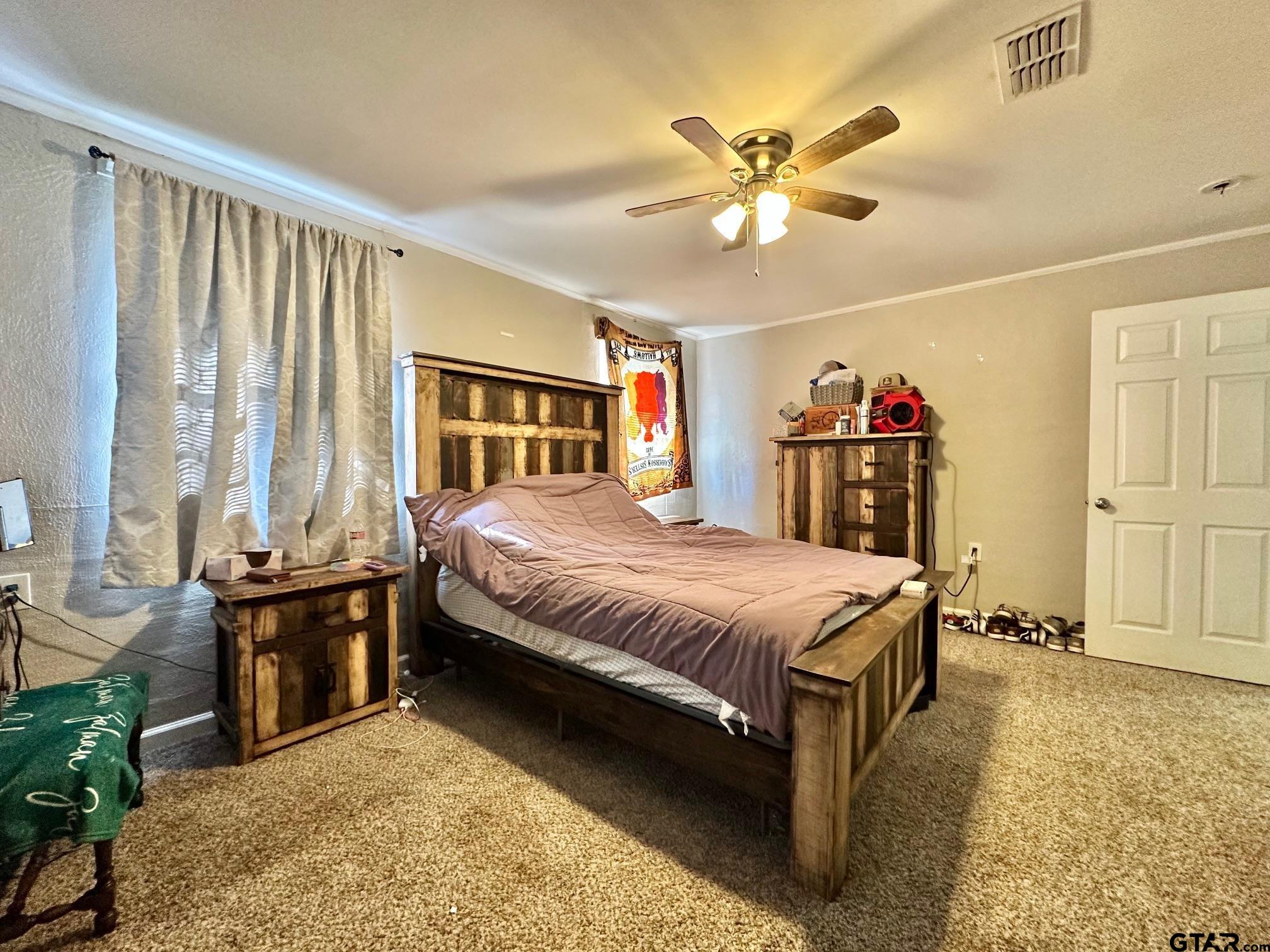 2601 East George Richey Road Longview, TX 75604 - Photo 22 of 26 a spacious bedroom with a bed and ceiling fan