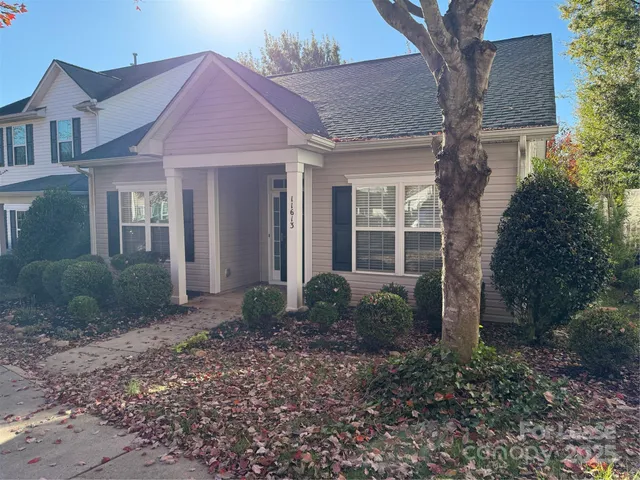 a view of a brick house with large windows and a large tree