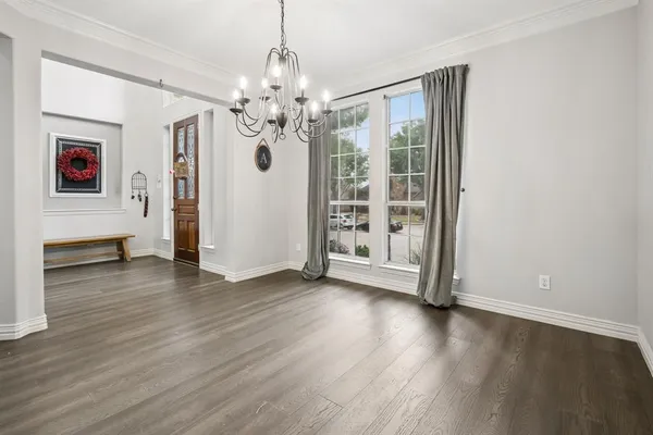 a view of a livingroom with wooden floor and chandelier