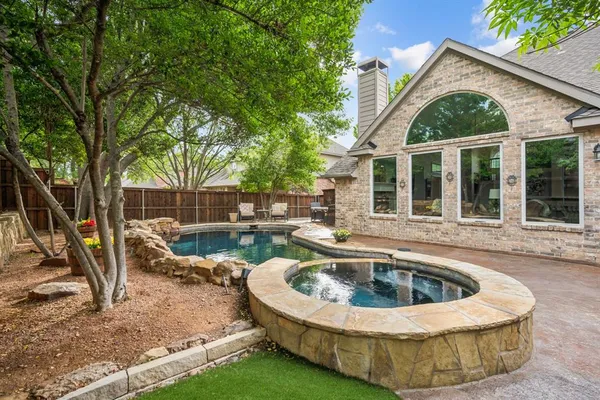 a view of a house with backyard swimming pool and sitting area