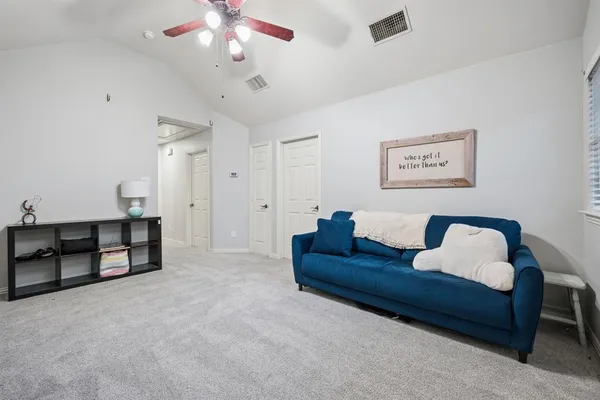 a spacious bedroom with a bed and a chandelier