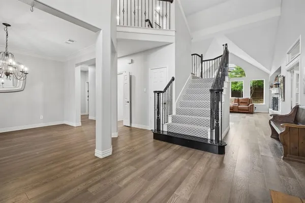 a view of a livingroom with wooden floor and stairs