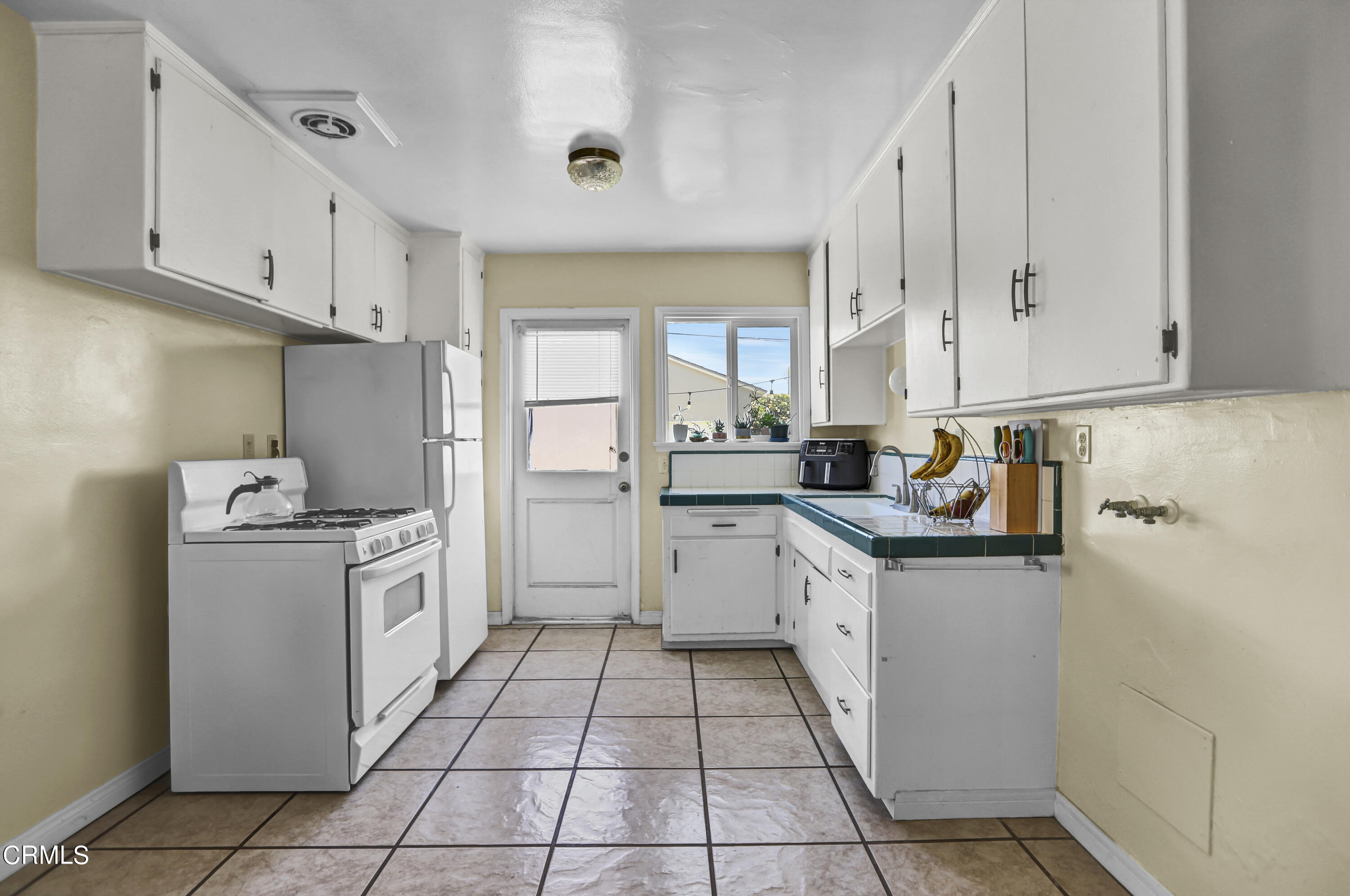 930 Doris Avenue Oxnard, CA 93030 - Photo 7 of 16 a kitchen with a white cabinets and white appliances