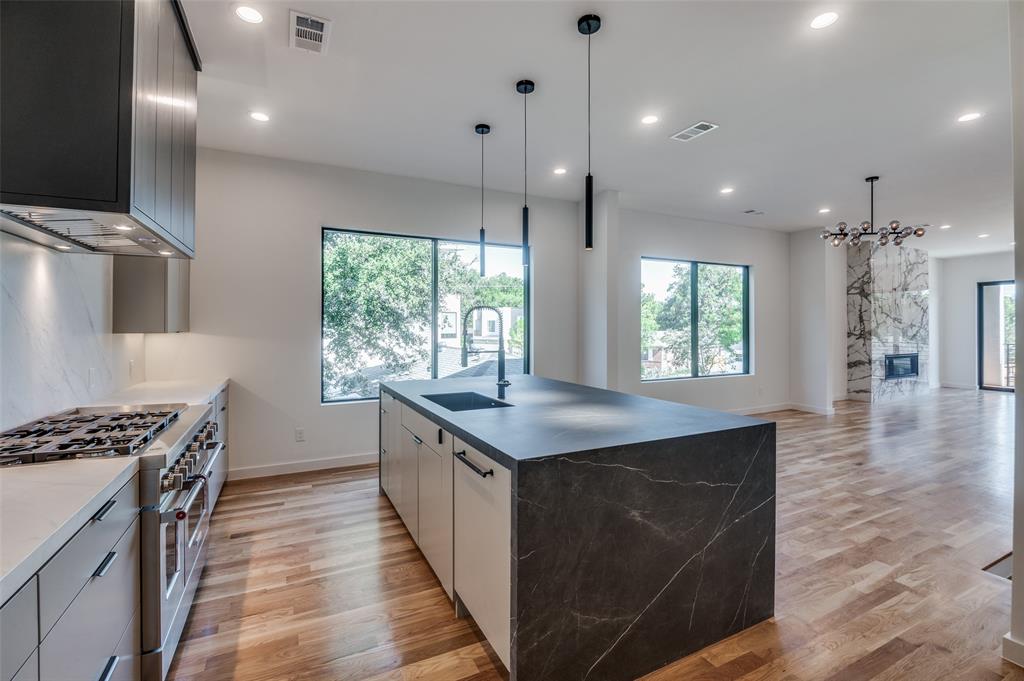4525 Weldon Street Dallas, TX 75204 - Photo 39 of 40 a kitchen with kitchen island a sink stove and wooden floor