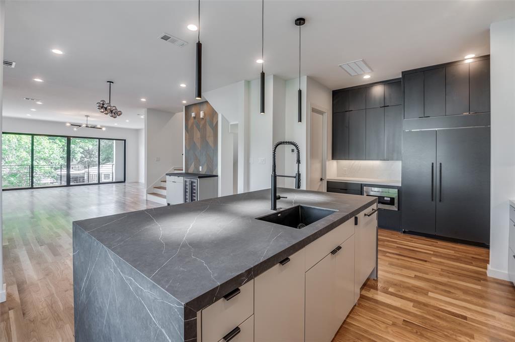 4525 Weldon Street Dallas, TX 75204 - Photo 40 of 40 a kitchen with stainless steel appliances granite countertop a sink a stove and a wooden floor