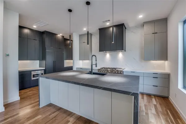 a kitchen with kitchen island a sink stove and wooden floor