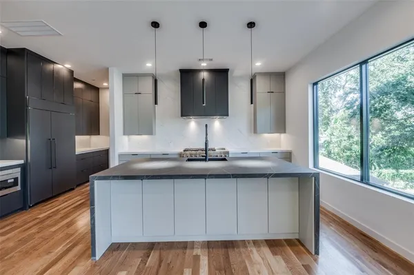 a kitchen with white cabinets stainless steel appliances and a large window