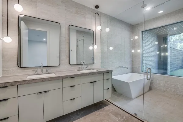 a spacious bathroom with a double vanity sink mirror and bathtub