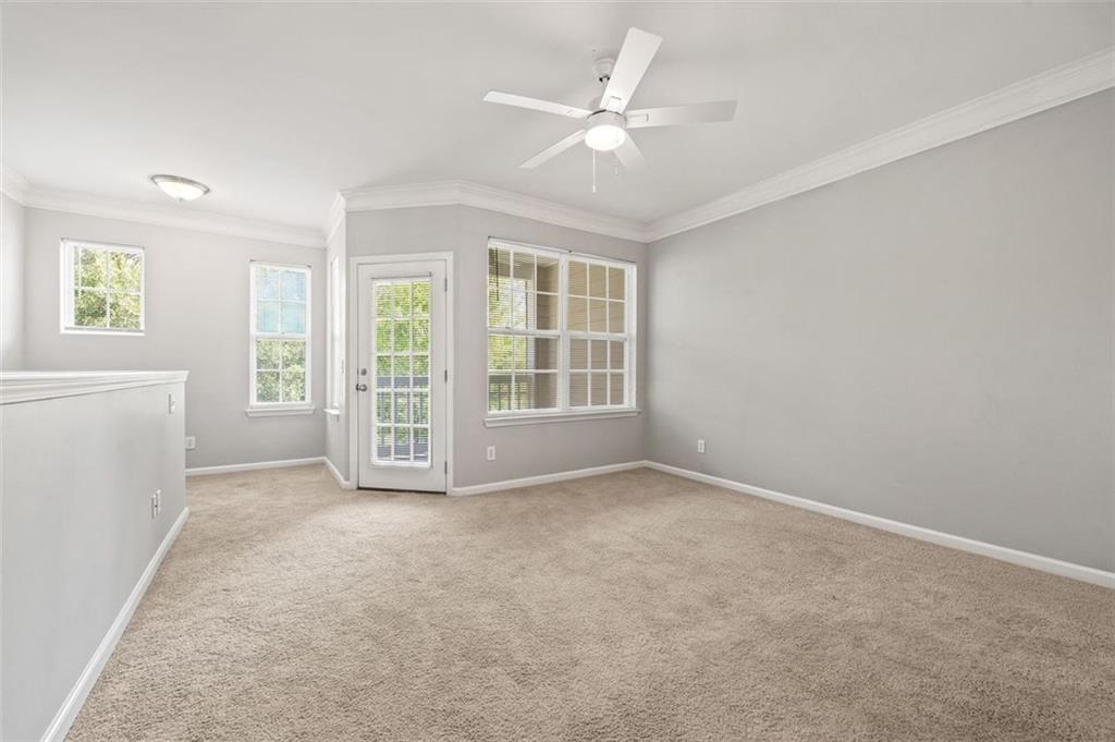 1752 Pryor Road Southwest, Unit 111 Atlanta, GA 30315 - Photo 2 of 21 an empty room with windows and ceiling fan
