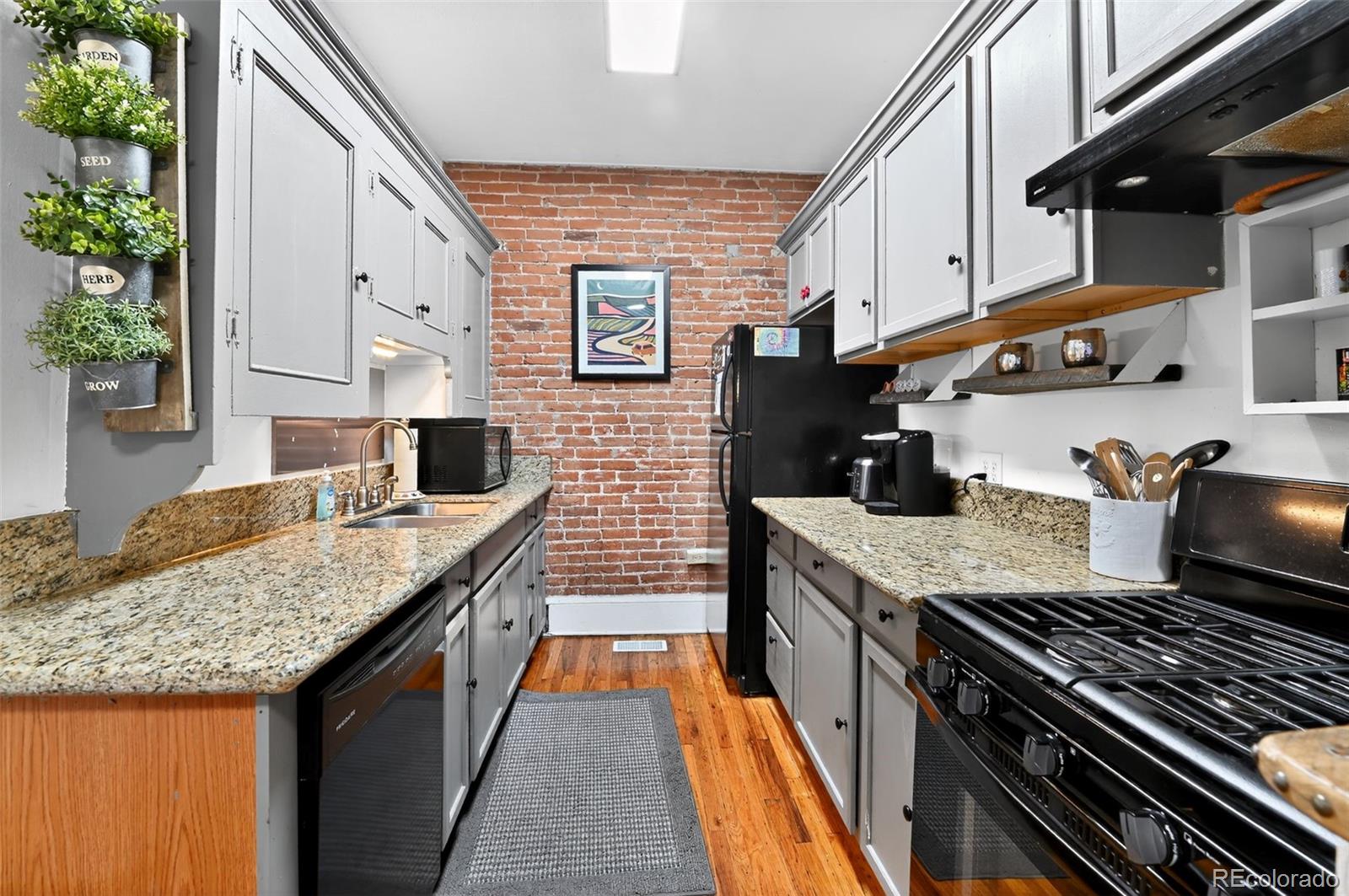 1608 Miner Street, Unit 2 Idaho Springs, CO 80452 - Photo 13 of 35 a kitchen with stainless steel appliances granite countertop a stove a sink and a microwave