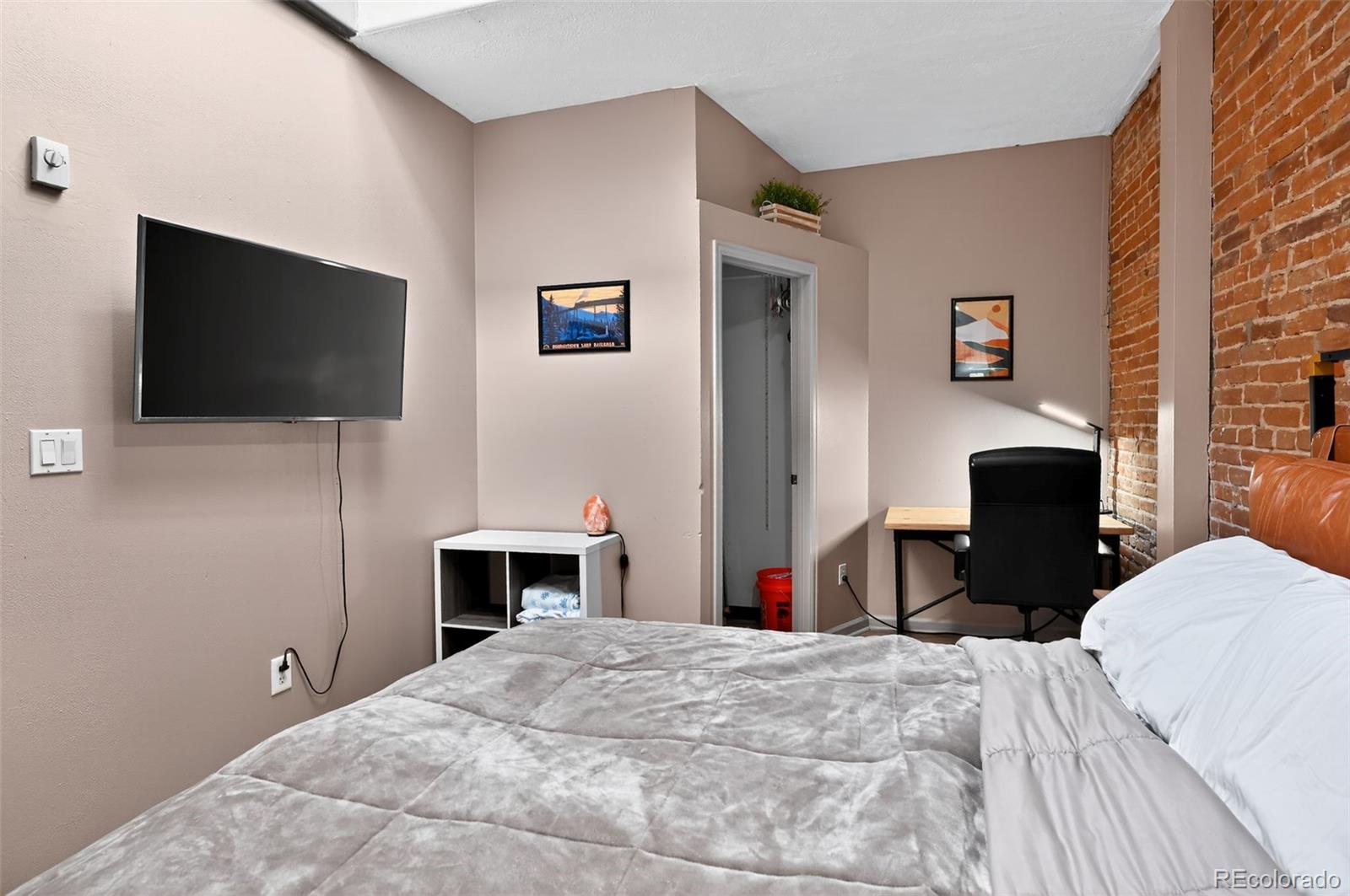 1608 Miner Street, Unit 2 Idaho Springs, CO 80452 - Photo 20 of 35 a bedroom with a bed and a flat screen tv