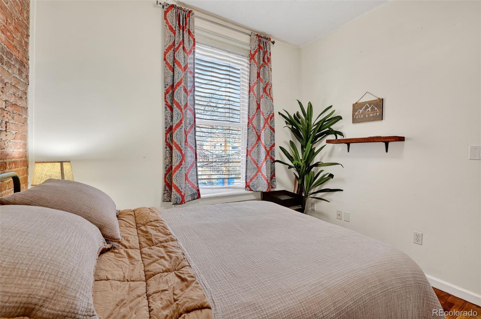 1608 Miner Street, Unit 2 Idaho Springs, CO 80452 - Photo 26 of 35 a bedroom with a large bed and a potted plant