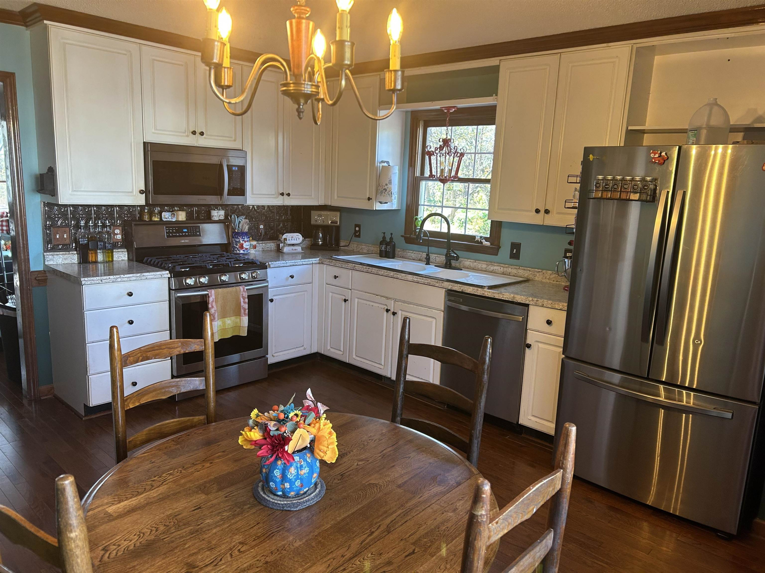 91 Violet Lane Coats, NC 27521 - Photo 5 of 19 a kitchen with stainless steel appliances granite countertop a refrigerator a stove a sink dishwasher a dining table and chairs with wooden floor