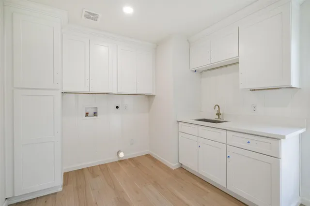 a view of cabinets a sink and dishwasher with wooden floor