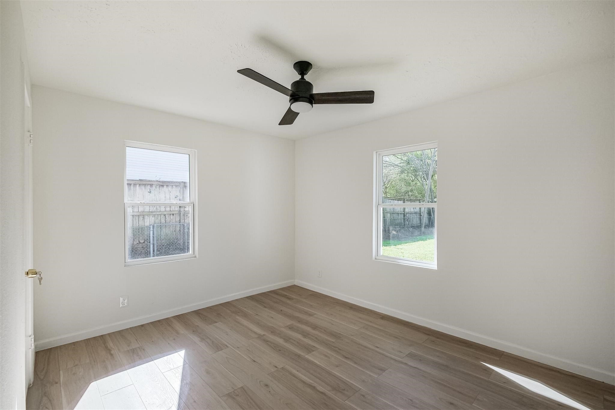 9419 Campbell Road Houston, TX 77080 - Photo 15 of 29 wooden floor in an empty room with a window