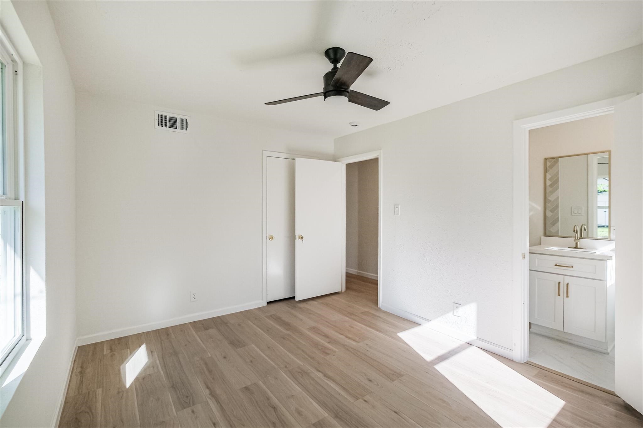 9419 Campbell Road Houston, TX 77080 - Photo 16 of 29 a view of empty room with wooden floor and fan