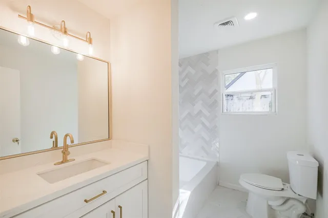 a bathroom with a sink a toilet and a mirror