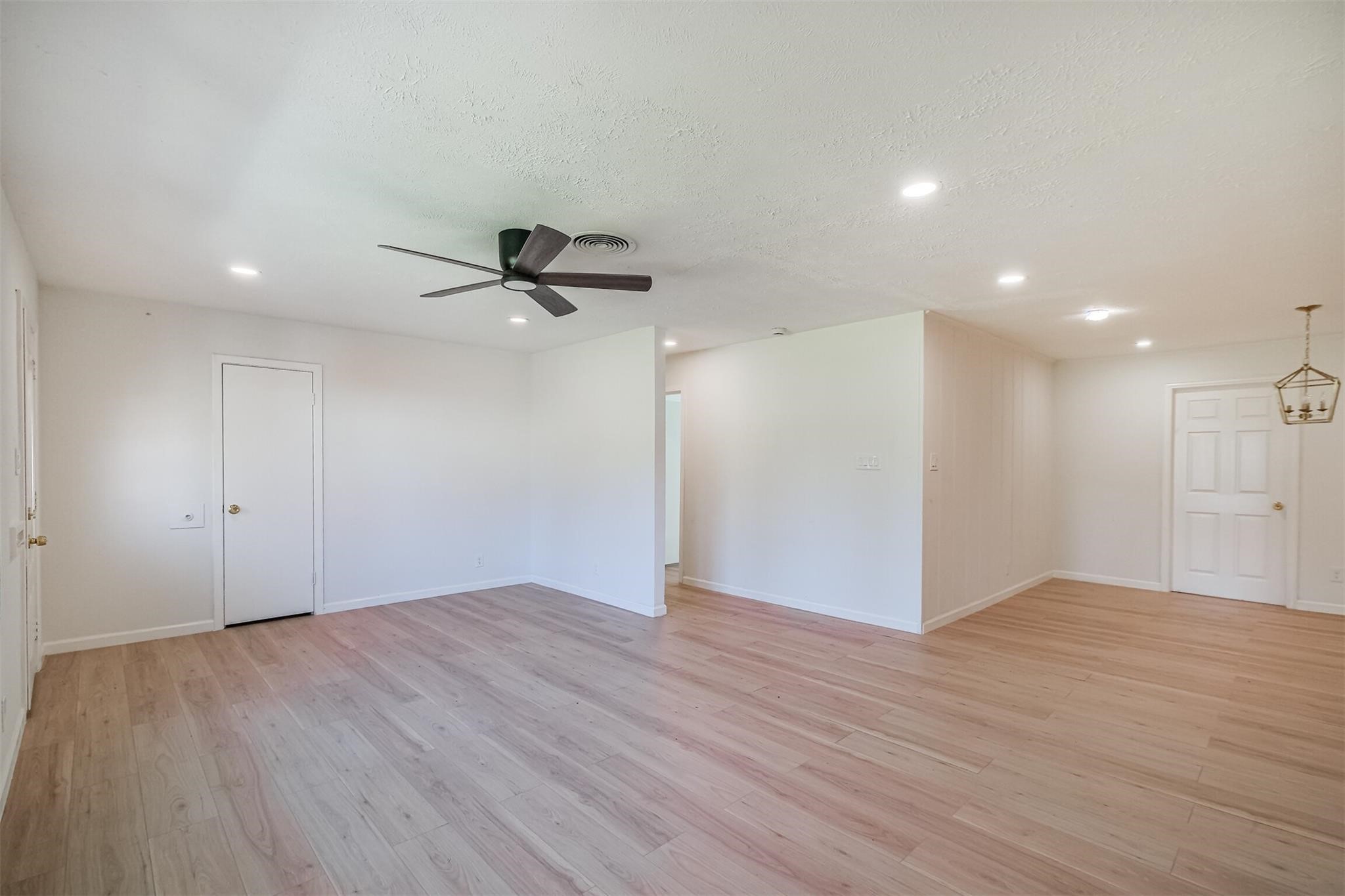 9419 Campbell Road Houston, TX 77080 - Photo 23 of 29 a view of an empty room with wooden floor and a ceiling fan