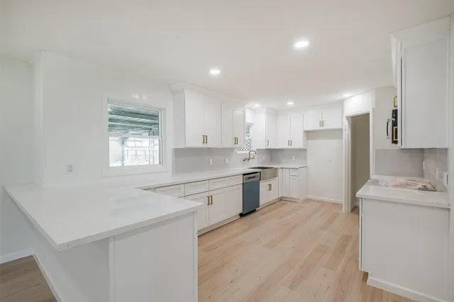 a kitchen with a sink a window and stainless steel appliances