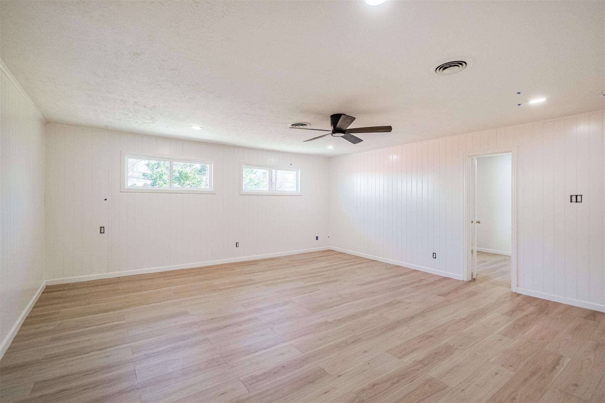 9419 Campbell Road Houston, TX 77080 - Photo 10 of 29 an empty room with wooden floor cabinet and windows