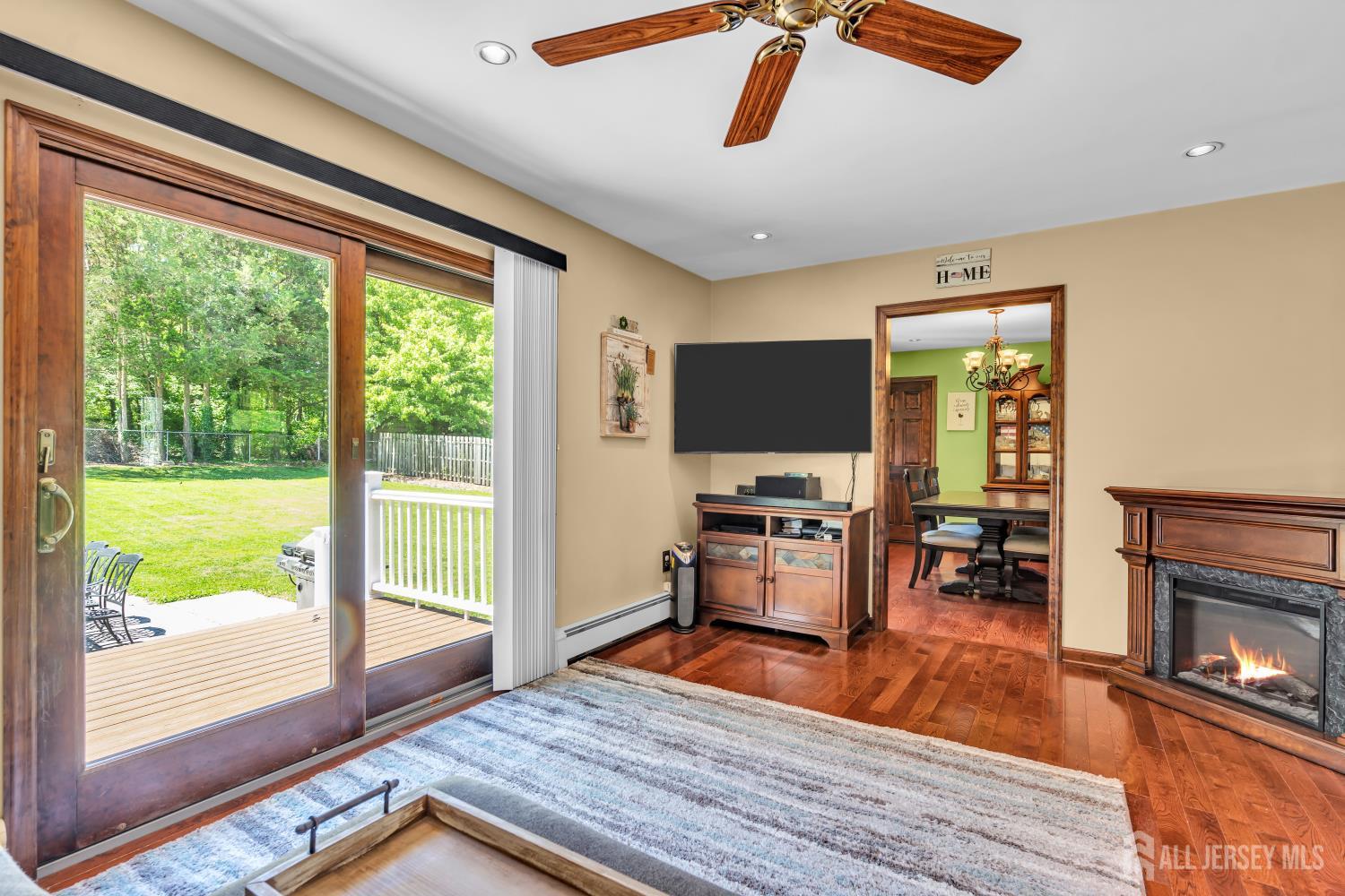 99 Schulmeister Road Old Bridge, NJ 08857 - Photo 11 of 49 a living room with furniture a flat screen tv and a floor to ceiling window