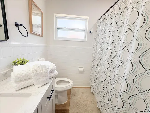 a bathroom with a sink and mirror with toilet