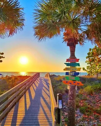 a view of a swimming pool with lawn chairs and wooden fence