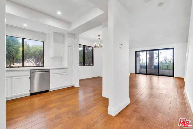 a view of a big room with wooden floor and windows
