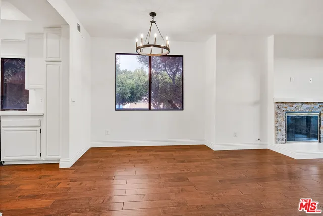 a view of empty room with wooden floor and fireplace