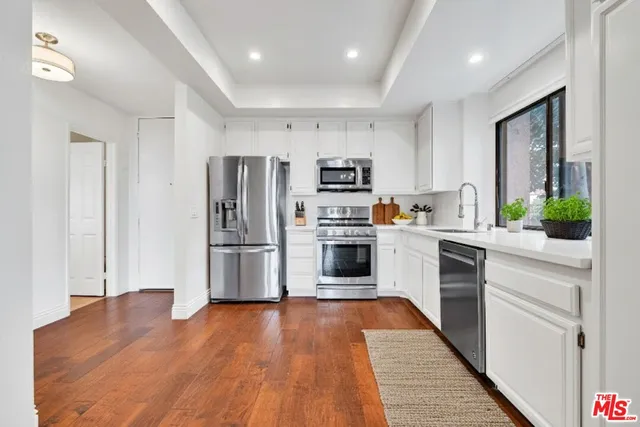 a kitchen with stainless steel appliances a refrigerator and a stove top oven