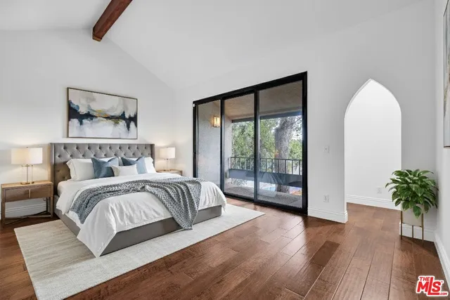 a bedroom with a large bed and a wooden floor