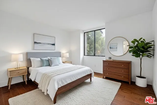 a bedroom with a bed a mirror and dresser