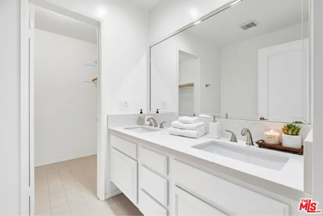 a bathroom with double sink and a mirror