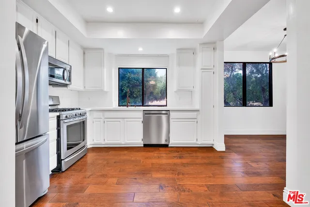 a kitchen with stainless steel appliances kitchen island granite countertop a stove a sink and a refrigerator