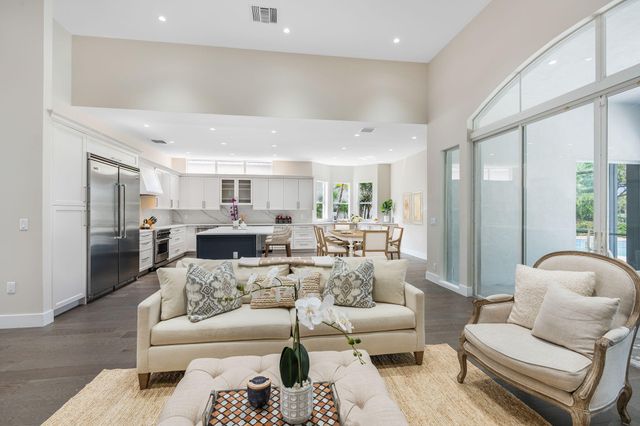 a living room with furniture kitchen view and a large window