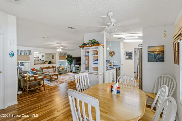 a living room with furniture kitchen view and a wooden floor