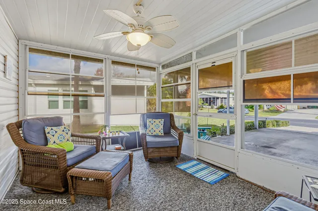 a living room with furniture and a floor to ceiling window