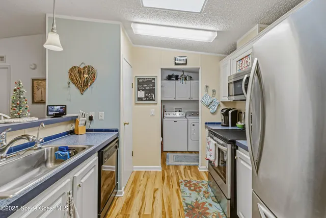 a view of a kitchen with fridge and workspace