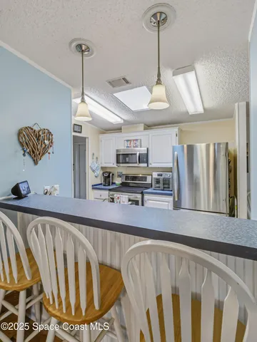a kitchen with stainless steel appliances granite countertop a sink window and cabinets
