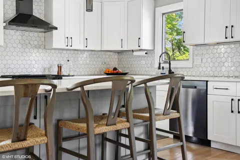 a kitchen with a table chairs refrigerator and cabinets
