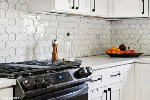 a stove top oven sitting inside of a kitchen