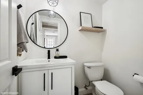 a bathroom with a toilet a sink and a mirror
